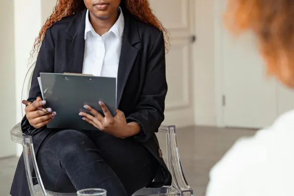 A woman holding a clipboard during a meeting
